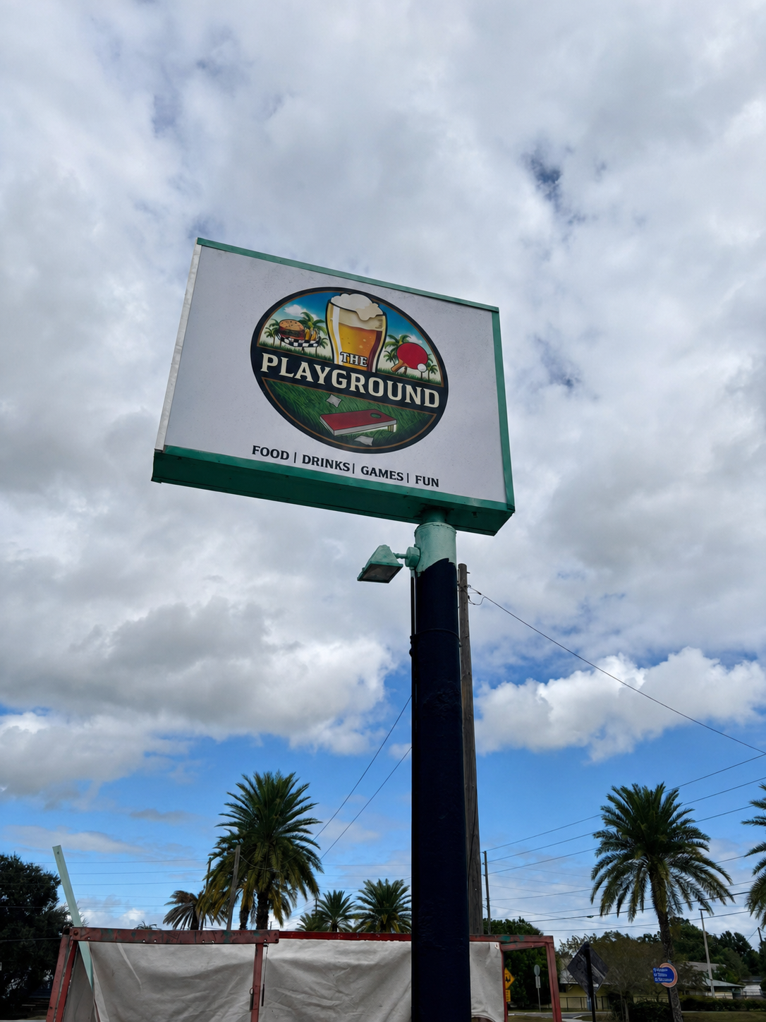Exterior pole sign reading The Playground and Food | Drinks | Games | Fun
