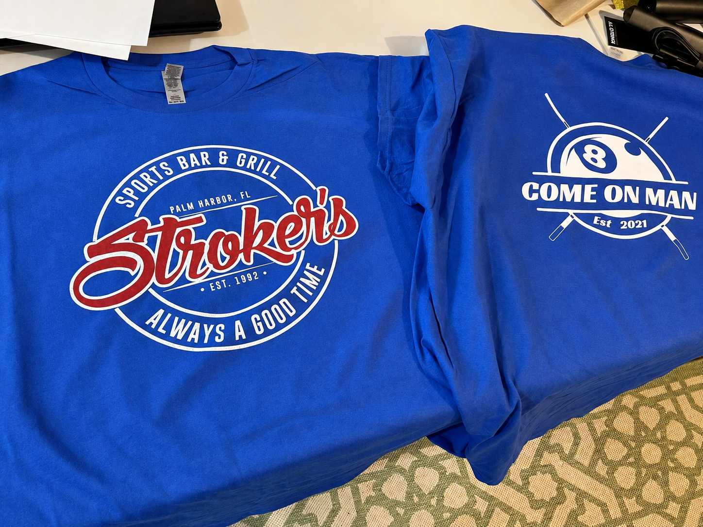 Blue branded printed shirts reading Stroker's Sports Bar & Grill and Come On Man